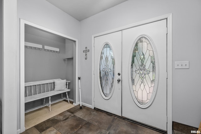 entrance foyer with french doors, stone finish flooring, and baseboards