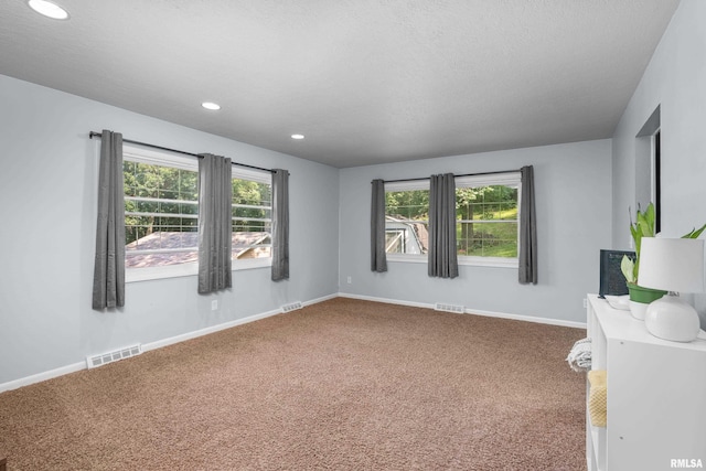 unfurnished room with visible vents, baseboards, and carpet