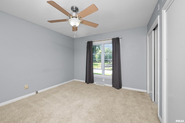 unfurnished bedroom with visible vents, light carpet, baseboards, and a closet