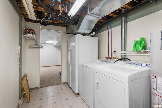 laundry area featuring light floors, baseboards, washing machine and clothes dryer, laundry area, and water heater