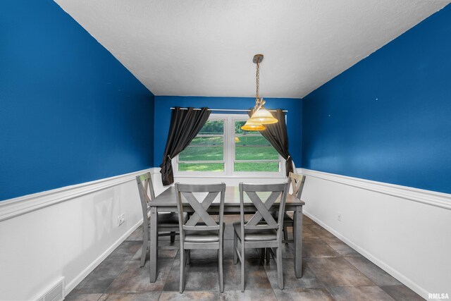 dining area featuring visible vents and a wainscoted wall