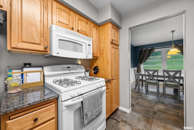 kitchen featuring white appliances, dark stone countertops, baseboards, and pendant lighting