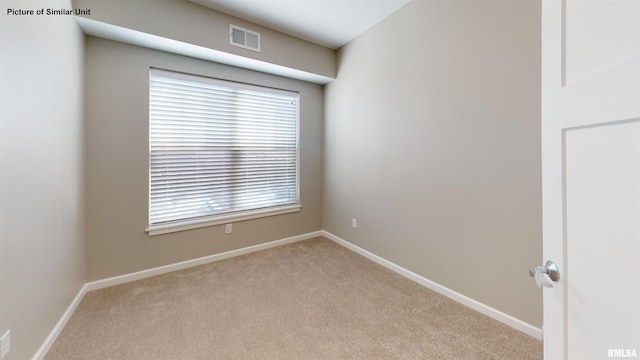 spare room with visible vents, carpet floors, and baseboards