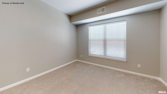 carpeted empty room featuring baseboards and visible vents