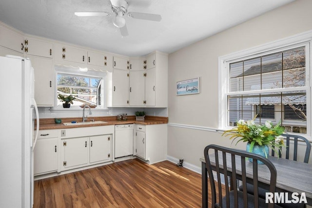 kitchen featuring dark wood-type flooring, a sink, wood counters, white cabinetry, and white appliances