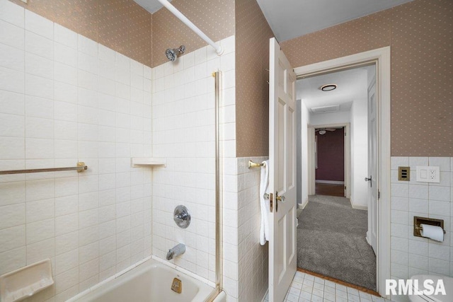 bathroom with wallpapered walls and  shower combination