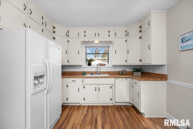 kitchen with tasteful backsplash, wood finished floors, white appliances, white cabinetry, and a sink