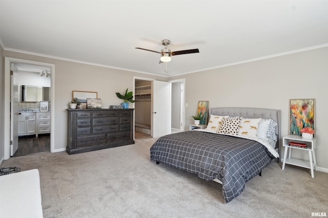 carpeted bedroom featuring a closet, crown molding, baseboards, ceiling fan, and a spacious closet