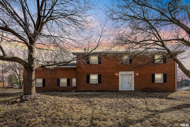 back of property at dusk with brick siding