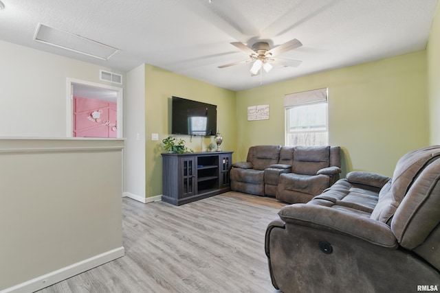 living room with visible vents, ceiling fan, baseboards, and wood finished floors