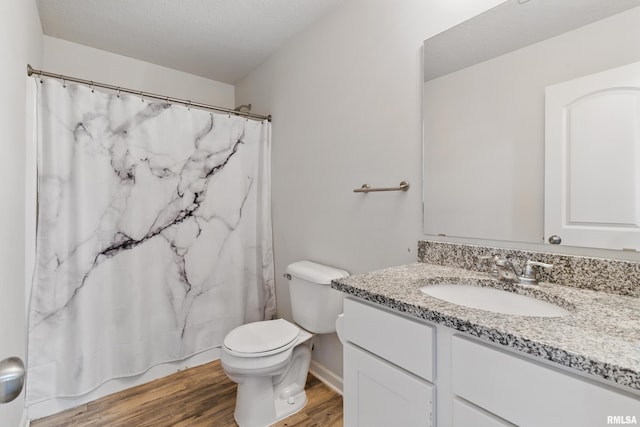 bathroom featuring a shower with curtain, toilet, a textured ceiling, wood finished floors, and vanity