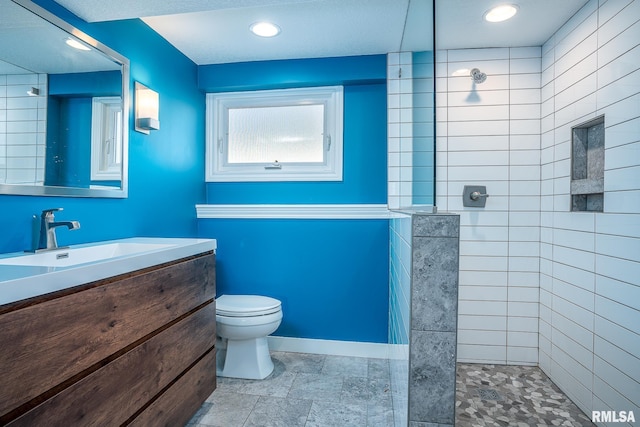 full bathroom featuring a walk in shower, baseboards, toilet, recessed lighting, and vanity