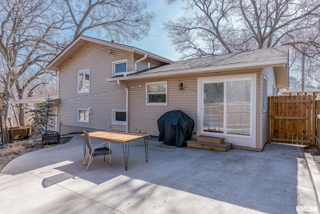 rear view of property with a gate, entry steps, a patio, fence, and outdoor dining area