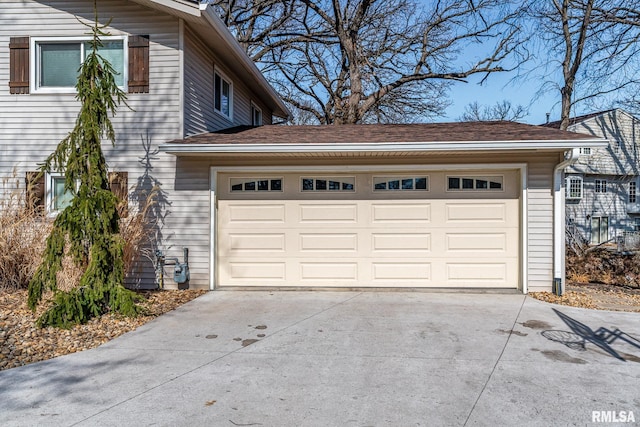 garage featuring concrete driveway