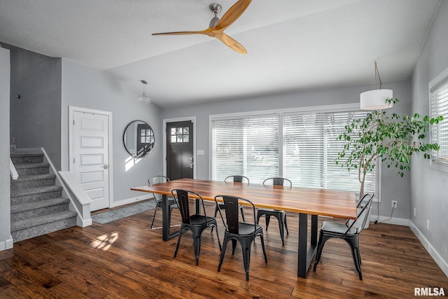 dining room with stairway, lofted ceiling, baseboards, and dark wood-style floors