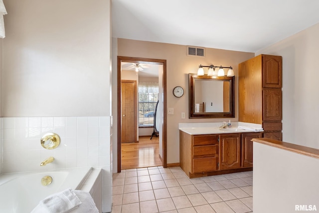 bathroom with vanity, a garden tub, visible vents, ceiling fan, and tile patterned floors