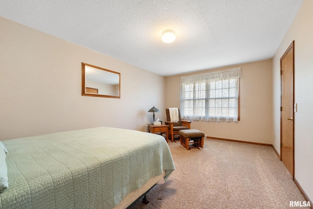 bedroom with baseboards, light colored carpet, and a textured ceiling