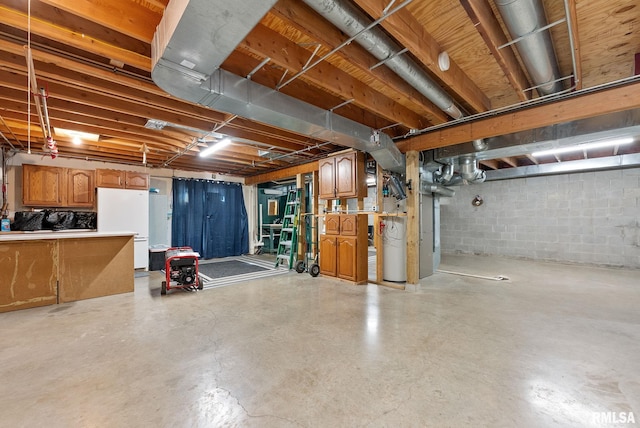 unfinished basement with concrete block wall and freestanding refrigerator