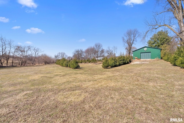 view of yard with an outbuilding, driveway, and a detached garage