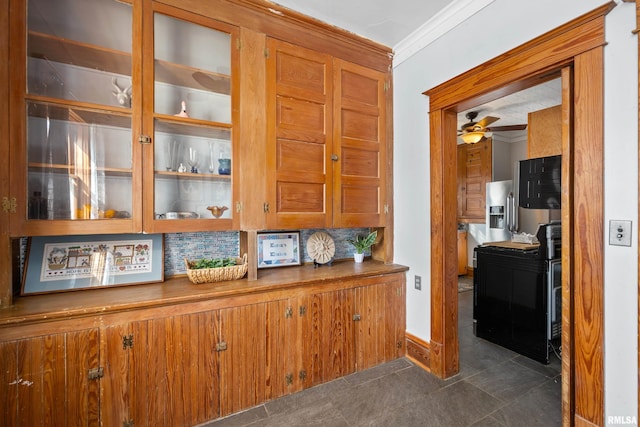 kitchen featuring tasteful backsplash, glass insert cabinets, dark tile patterned floors, ornamental molding, and brown cabinetry