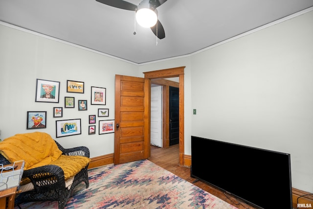 sitting room featuring ceiling fan, baseboards, and wood finished floors