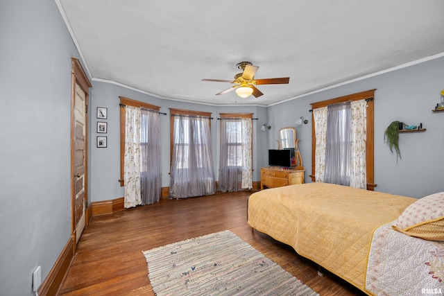 bedroom with ceiling fan, crown molding, baseboards, and wood finished floors