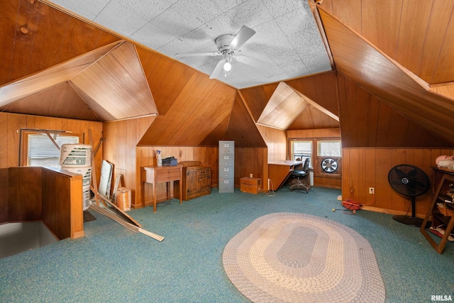 additional living space with vaulted ceiling, carpet, and wood walls