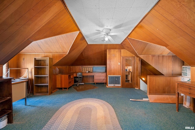 interior space with wooden walls, ceiling fan, visible vents, and vaulted ceiling