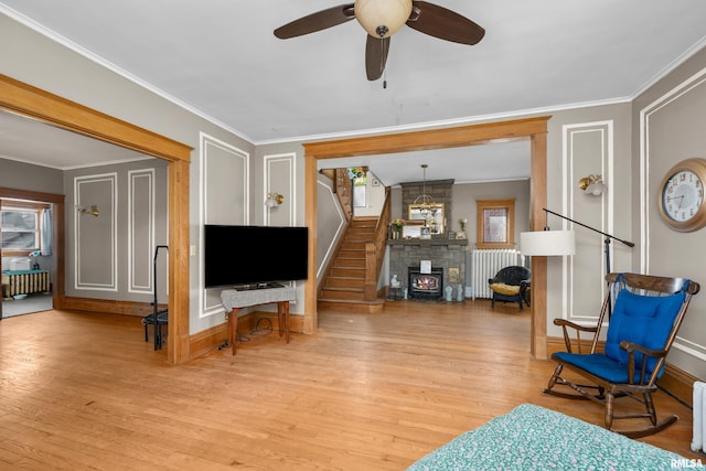 sitting room featuring stairway, radiator, ornamental molding, and light wood finished floors