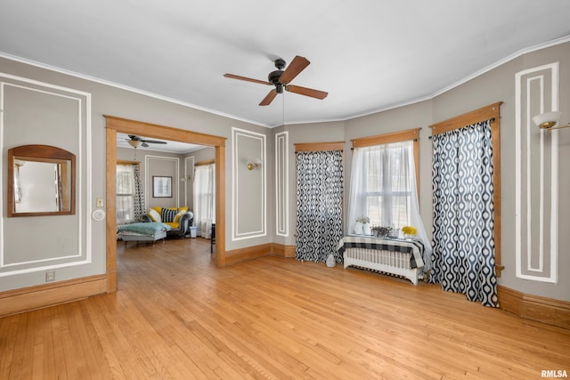 unfurnished room featuring a ceiling fan, crown molding, wood finished floors, and baseboards