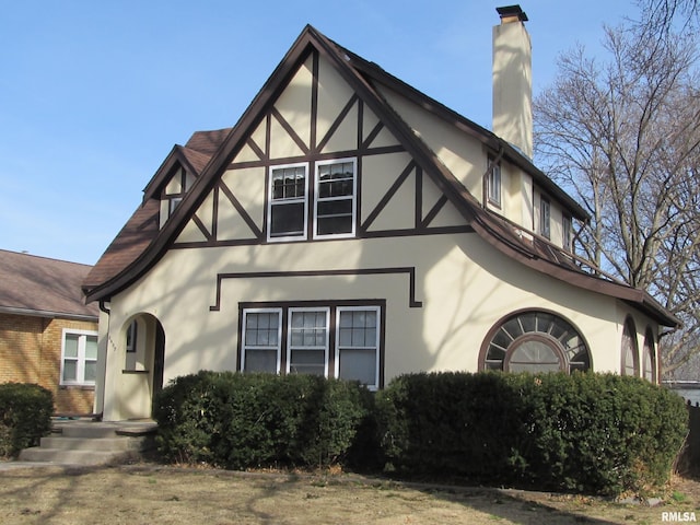 view of front of home featuring stucco siding and a chimney