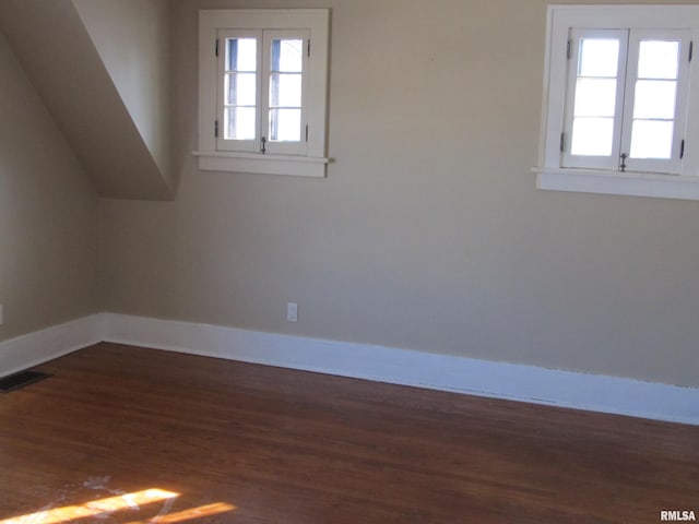 additional living space featuring visible vents, plenty of natural light, baseboards, and wood finished floors