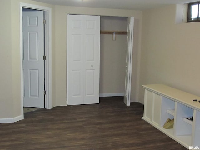 unfurnished bedroom with a closet and dark wood-style flooring