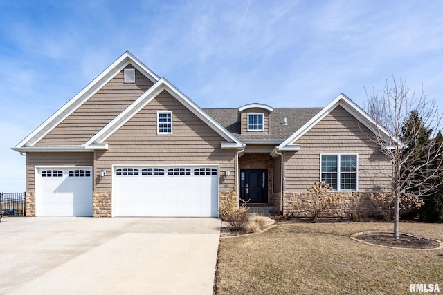 view of front of property featuring stone siding, driveway, and a shingled roof