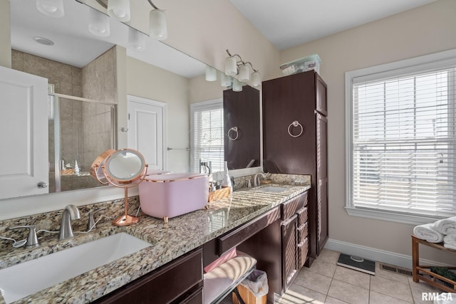 bathroom featuring a sink, baseboards, a stall shower, and tile patterned floors