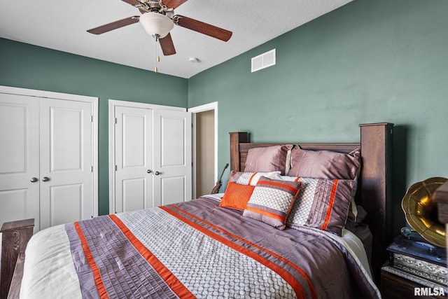 bedroom featuring visible vents, two closets, and ceiling fan