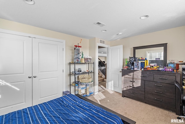 bedroom featuring visible vents, a closet, and light carpet