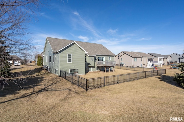 back of house with fence, a yard, a residential view, roof with shingles, and a wooden deck