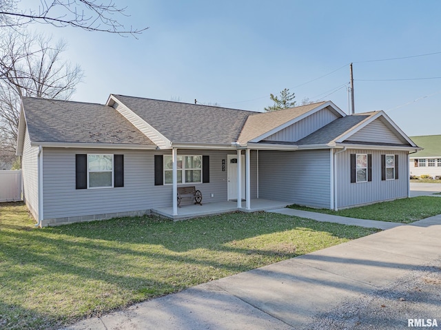 ranch-style home featuring a porch, a shingled roof, and a front lawn