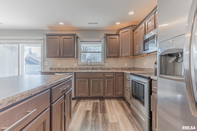 kitchen featuring visible vents, recessed lighting, appliances with stainless steel finishes, wood finished floors, and a sink