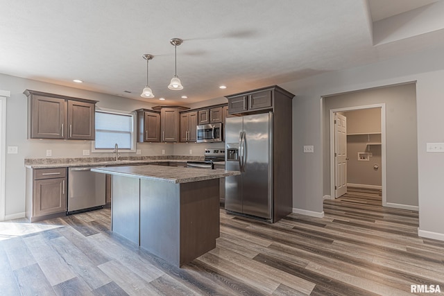 kitchen featuring dark brown cabinets, baseboards, appliances with stainless steel finishes, and dark wood-style floors