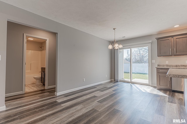 unfurnished dining area featuring a chandelier, visible vents, baseboards, and dark wood-style flooring