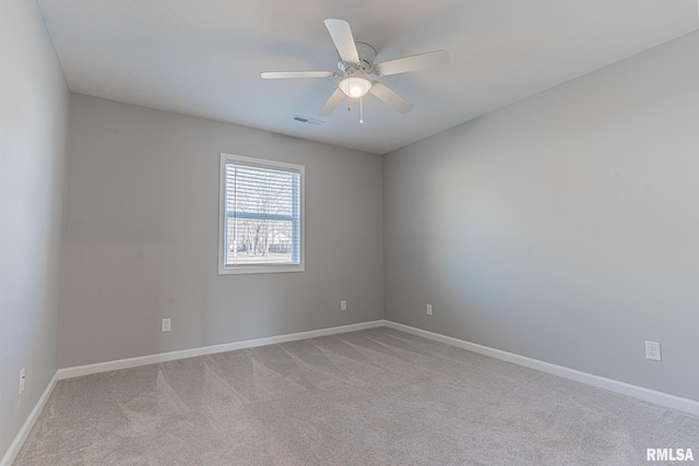 empty room featuring a ceiling fan, light colored carpet, visible vents, and baseboards