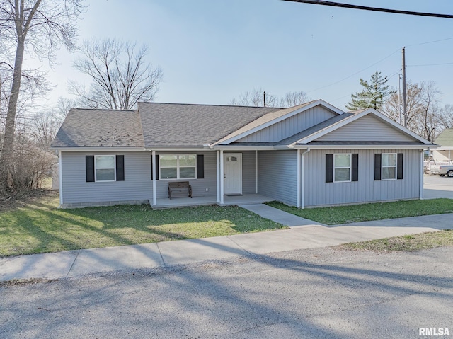 single story home featuring covered porch, a front lawn, and roof with shingles