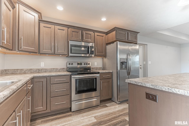 kitchen featuring recessed lighting, stainless steel appliances, light wood-style flooring, and light countertops