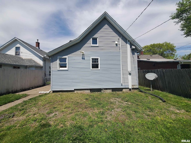 1523 W 13th St, Davenport, IA 52804 - view of home's exterior with entry steps, fence, a shingled roof, and a chimney