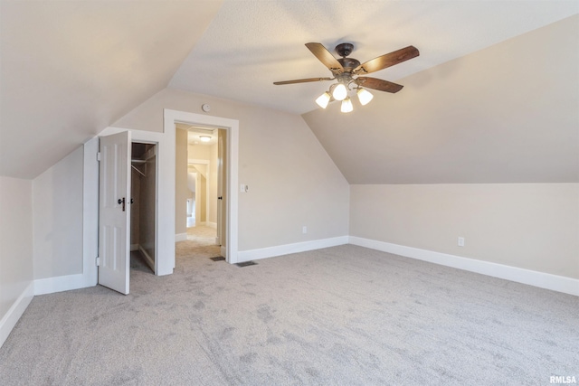 additional living space featuring vaulted ceiling, a ceiling fan, baseboards, and carpet floors