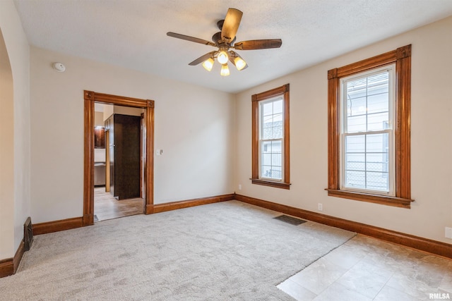 empty room with carpet, visible vents, and baseboards