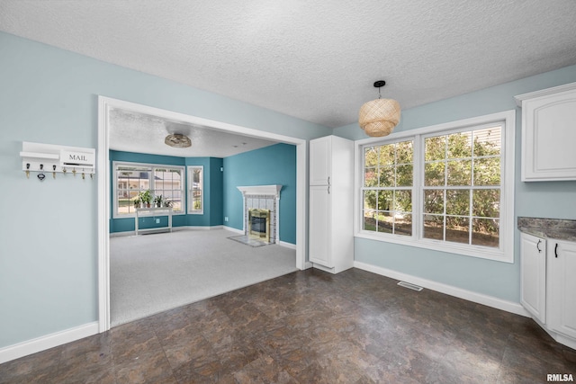 unfurnished living room featuring baseboards, a healthy amount of sunlight, and a fireplace