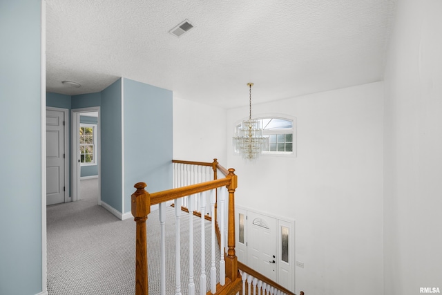 staircase featuring a notable chandelier, carpet, visible vents, and a healthy amount of sunlight